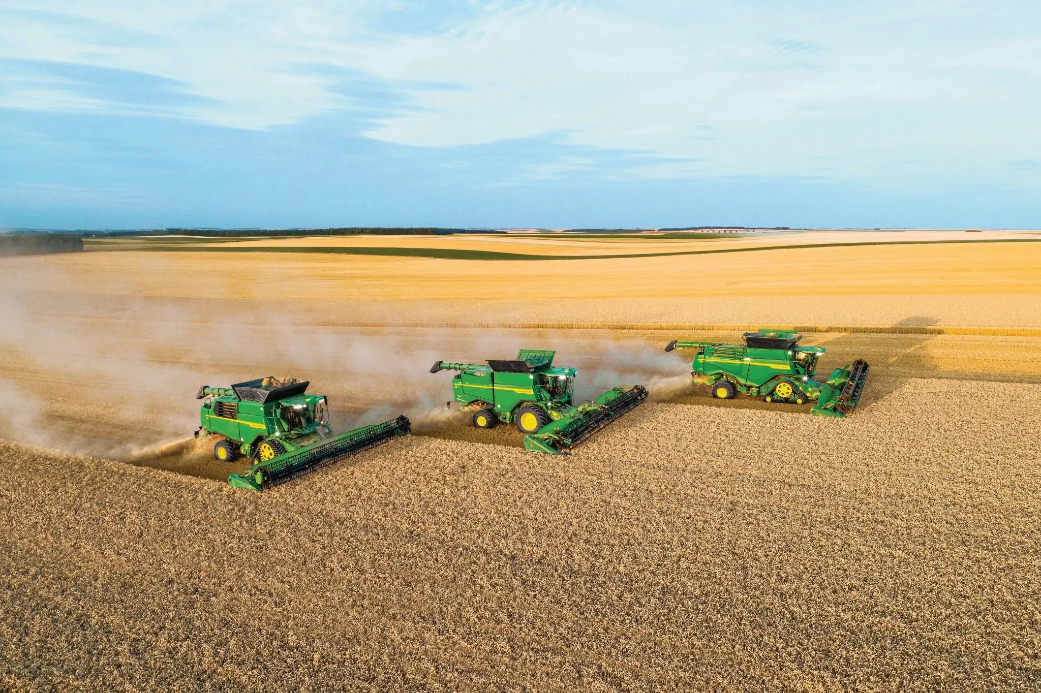 Image with three machines harvesting a field